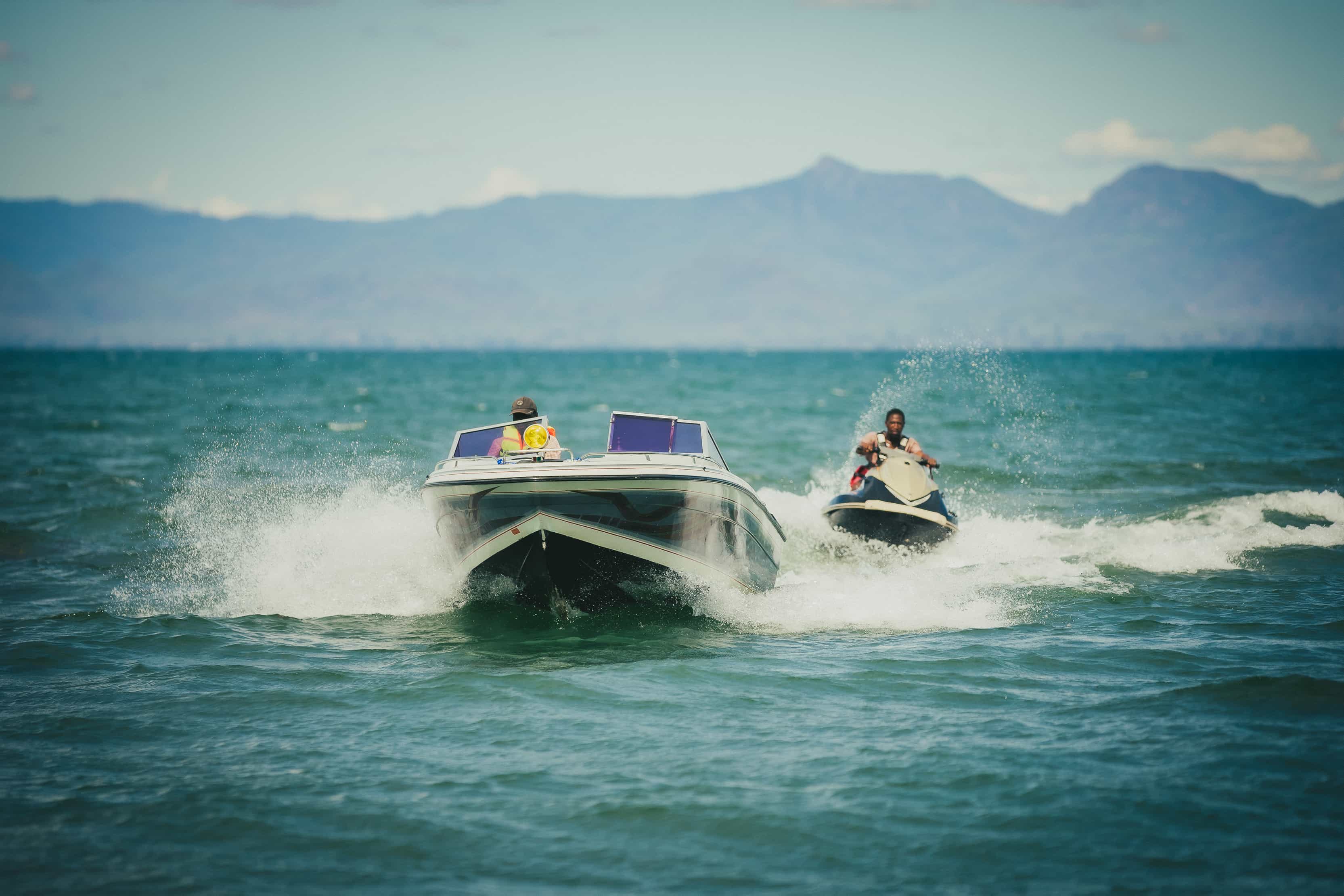 A boat and a jet ski riding in the lake