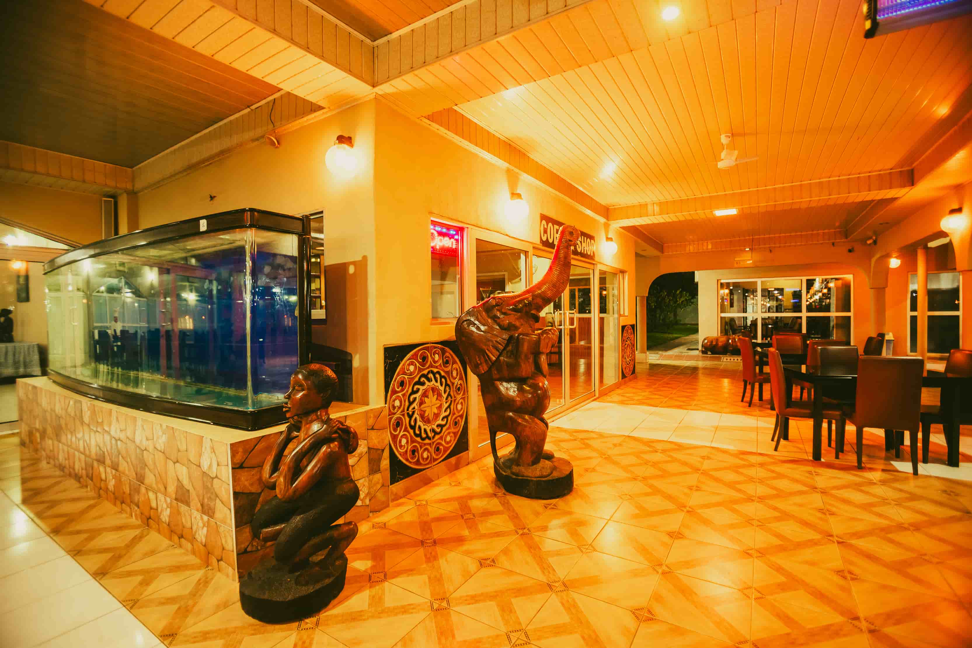side view of coffee shop with large aquarium besides it at night