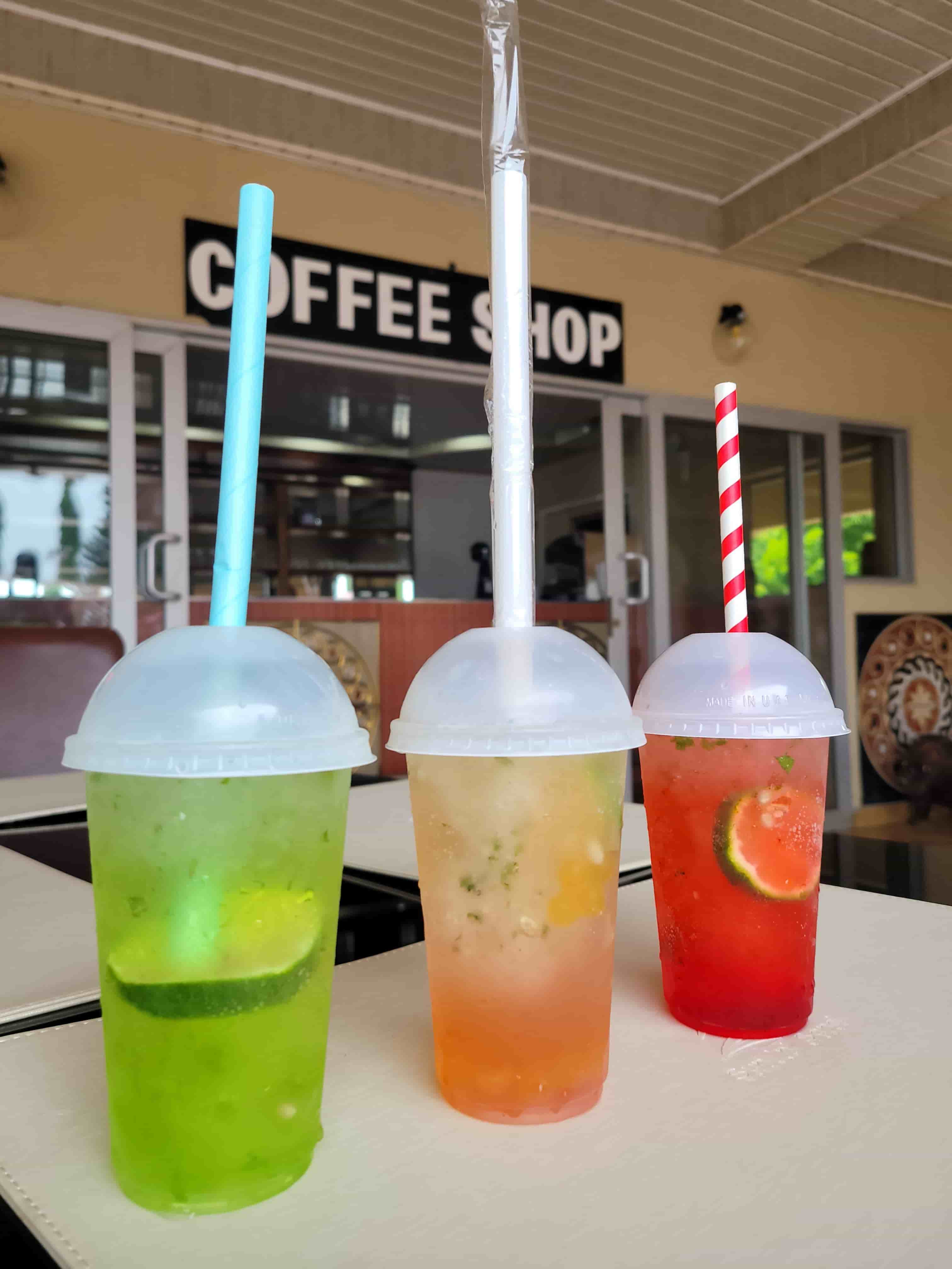 3 mocktails outside on coffee shop table with coffee shop sign