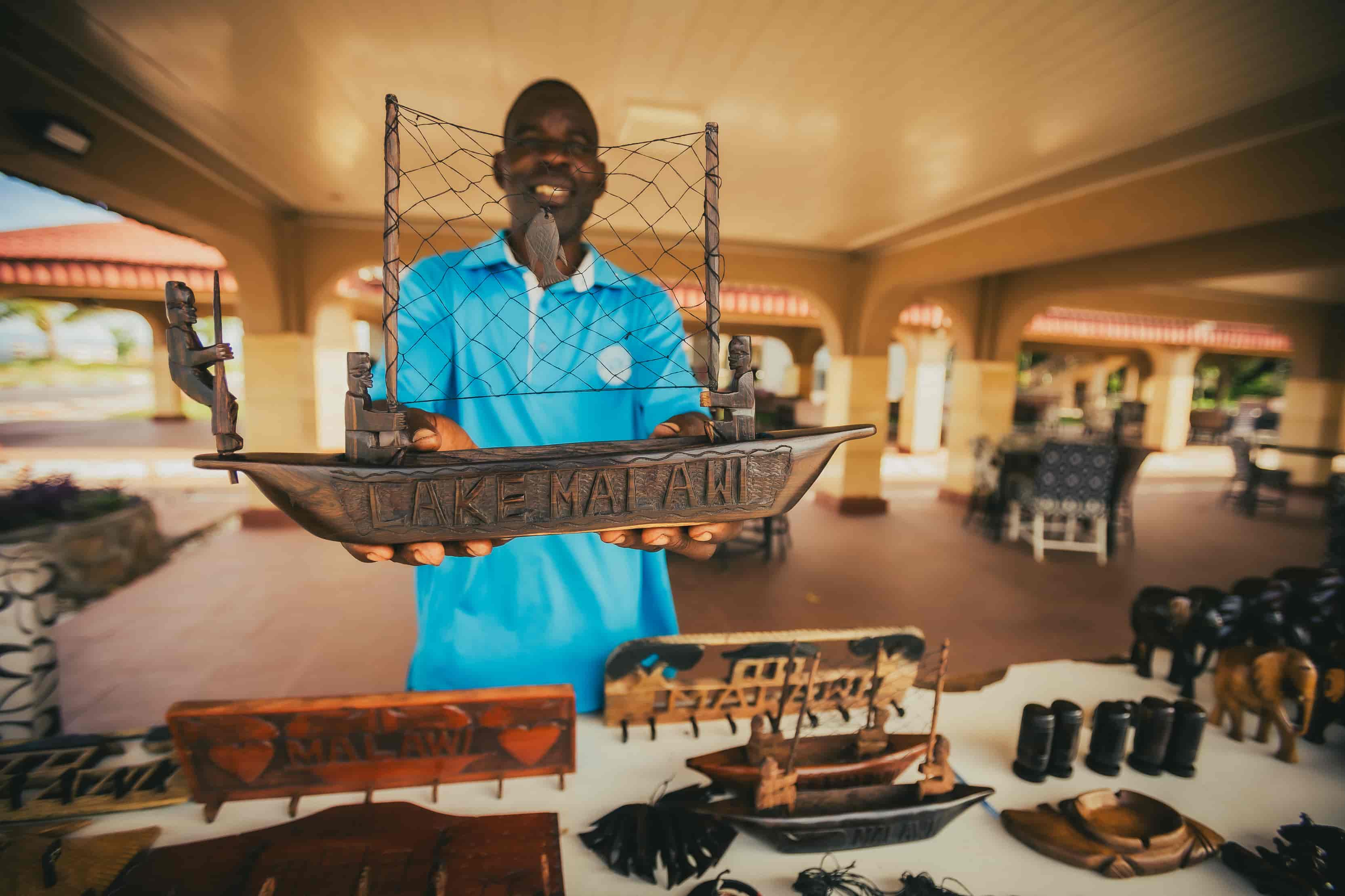 Man holding hand made wooden boat